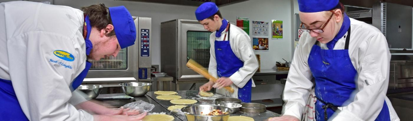 Three WMC NVQ Professional Cookery Advanced Diploma students working inside hospitality classroom