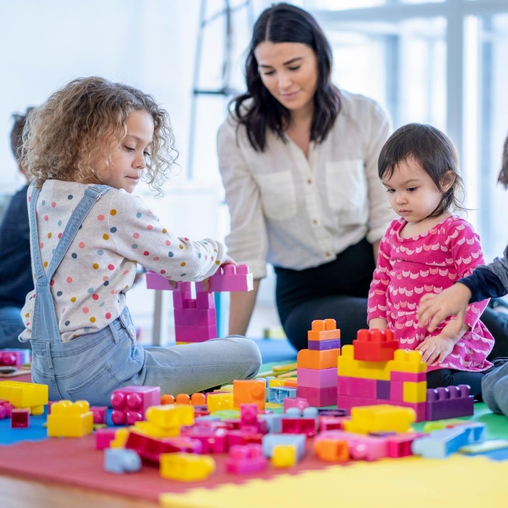 teacher with young students playing with toys