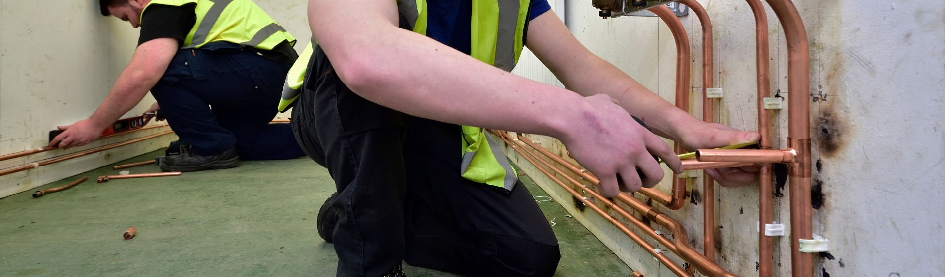 WMC Plumbing Studies student working on a wall