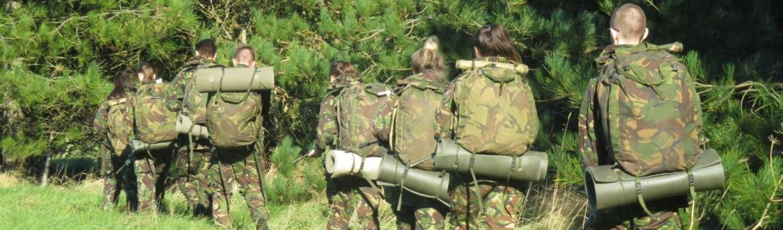 A group of WMC Public and Uniformed Services students wearing camouflage on a field