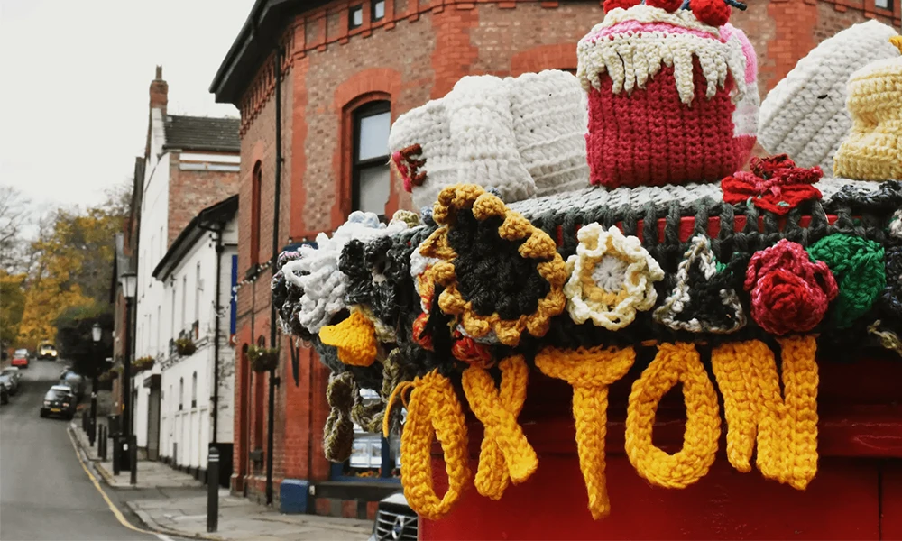 Red post box with crochet word 'Oxton'