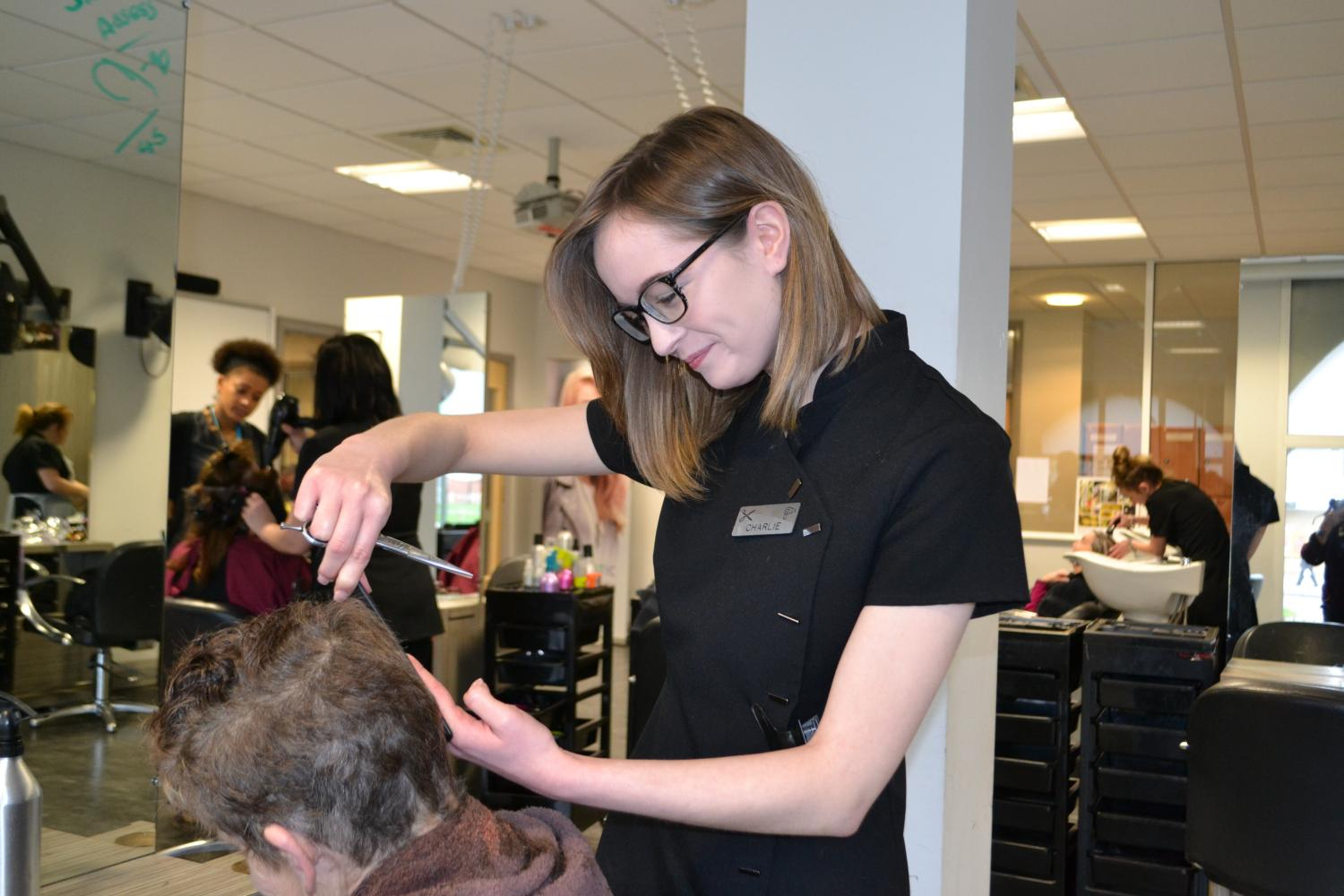 Wirral Met hairdressing student performing on a male's hair 
