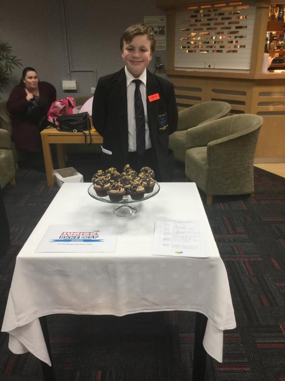 Josh Hall from Bebington High School standing in front of his cake called Wirral Whip at the Bake Off 2017