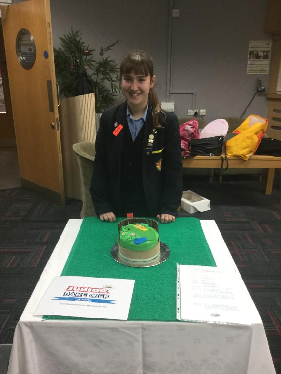 Laura Robinson from Prenton High School standing in front of her cake which is based on a golf theme at the Bake Off 2017