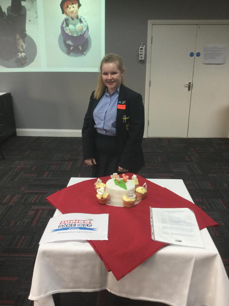 Libby McDonnell from Prenton High School standing in front of her cake based on a Wirral landmark at the Bake Off 2017