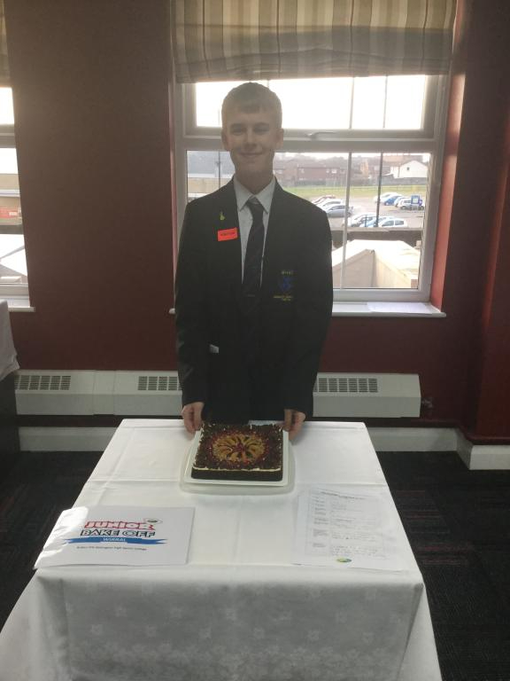 Ruben Pitt from Bebington High School standing in front of his cake based on a flower bed at Birkenhead Park for the Bake Off 2017