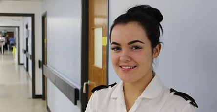 Arrowe Park Hospital apprentice wearing a white uniform standing in a corridor