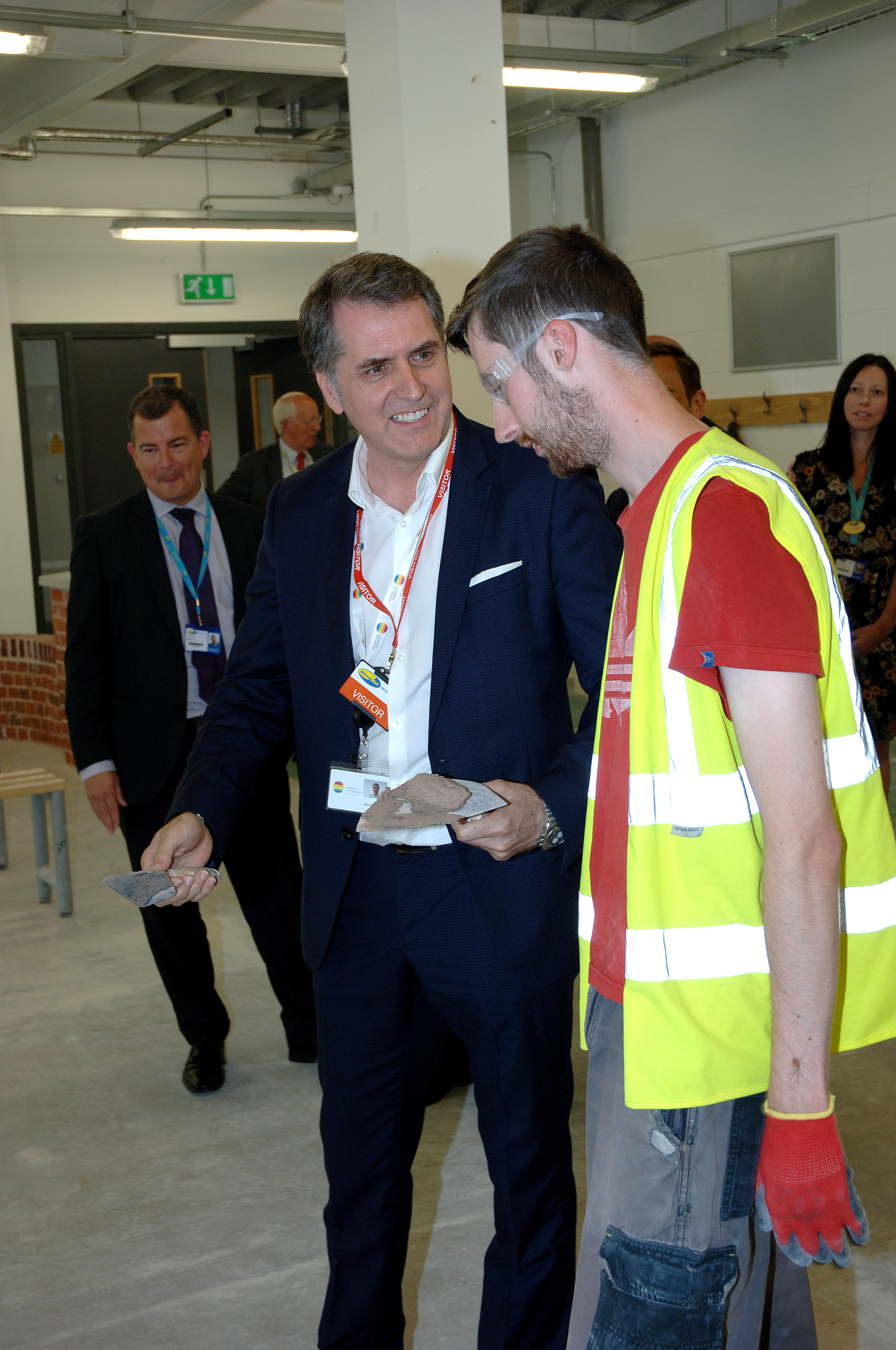 Metro Mayor Steve Rotheram speaking to a Wirral Met student wearing a hi-vis jacket at the Wirral Wates campus