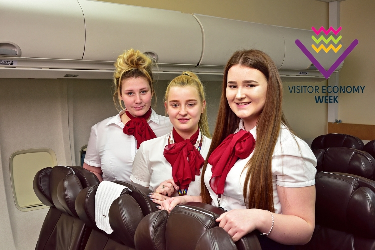 Travel and Tourism students standing in the airplane classroom in wirral Met's Conway Park Campus