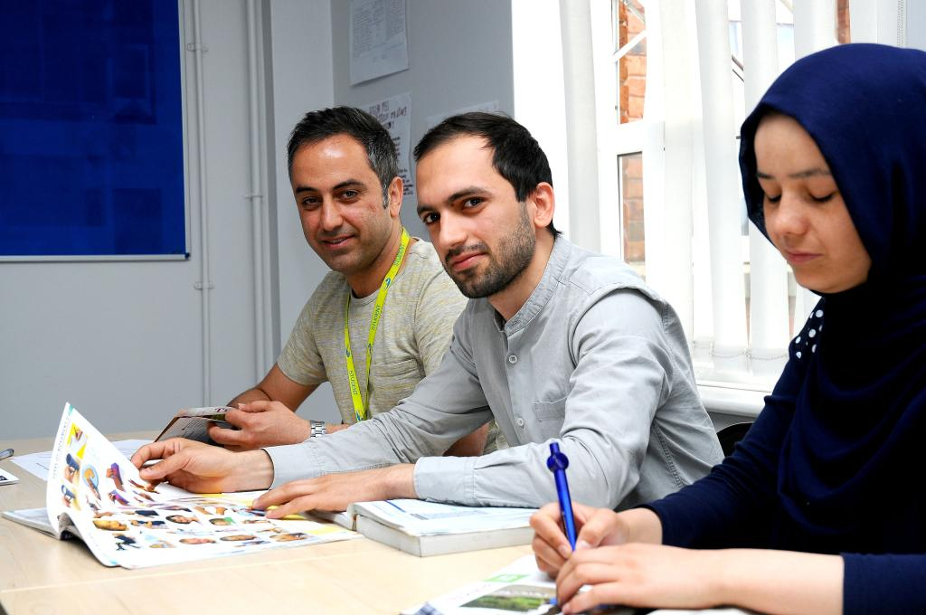 Three Wirral Met students sat at a desk doing work