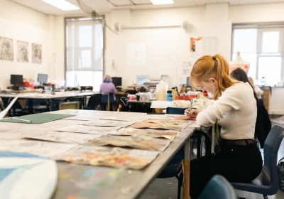 Female Part Time Art And Design Student Inside A Classroom Painting