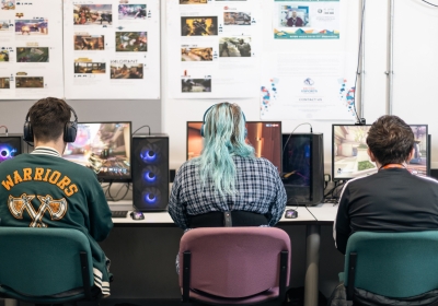 Three Part Time Computing And IT Students Wearing Virtual Reality Headsets In Classroom