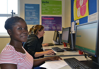 Three English And Maths Part Time Students Sat At Computers In Classroom