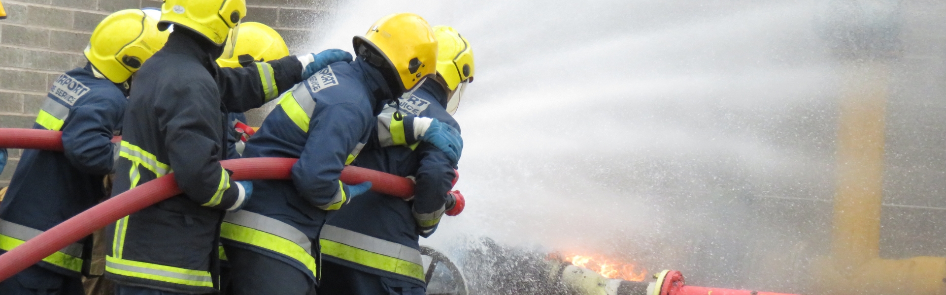 Public Services students putting out fire using hose