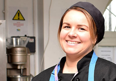 Female Hospitality And Catering Apprentice Standing Inside Training Kitchen