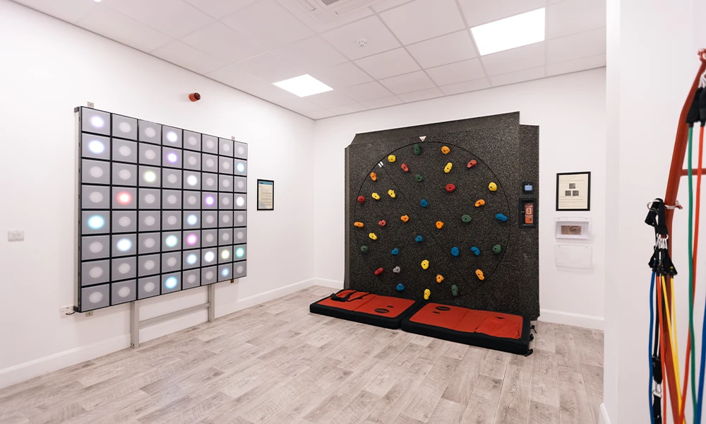 A climbing wall and light wall in a white room