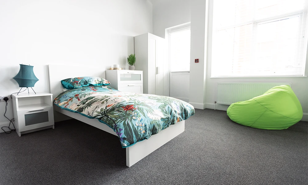 Bedroom with a green beanbag a bed and wardrobe 