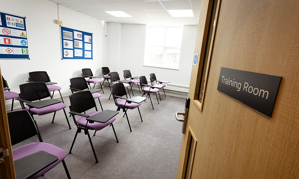 A room with purple chairs lined up saying training room
