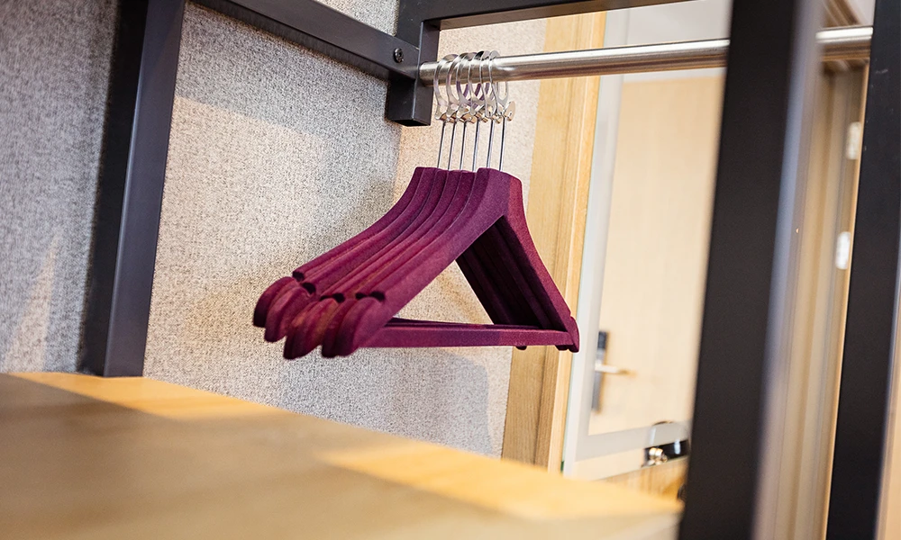purple coat hangers on a rail