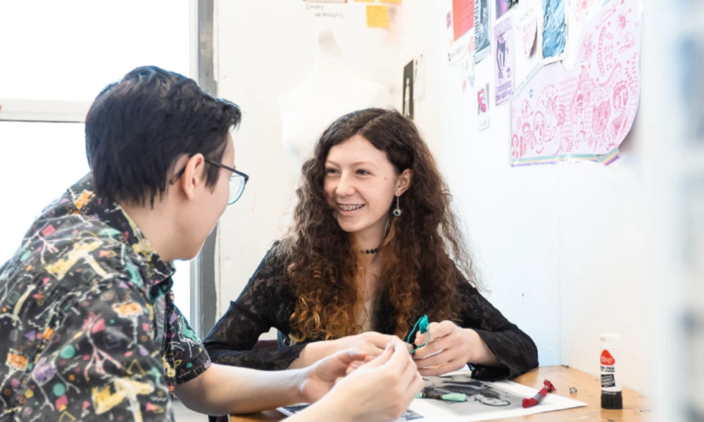 Breena Sinclair sitting inside classroom with another student.