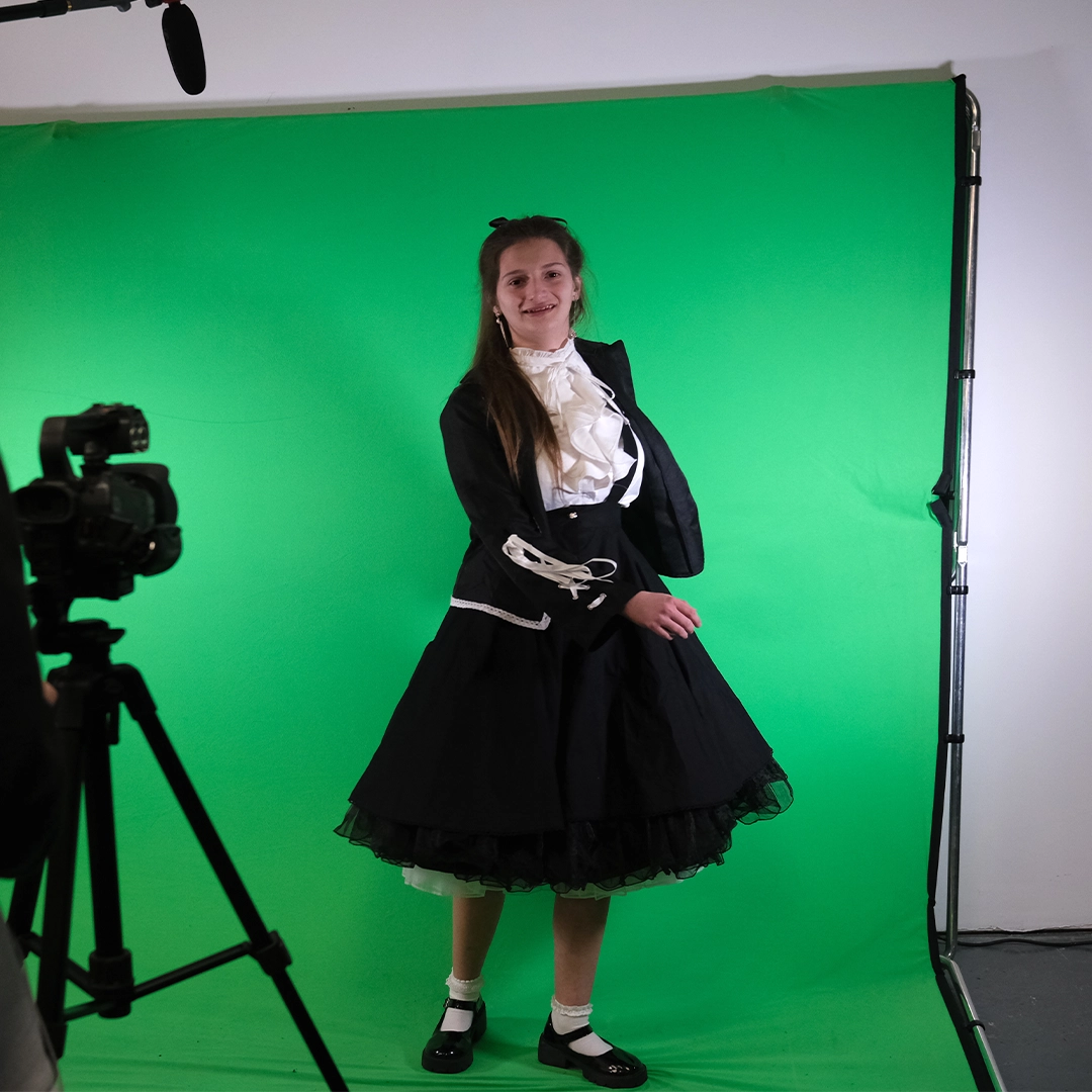 Creative Media case study Ruby Murphy standing in front of the green screen inside the classroom in Twelve Quays