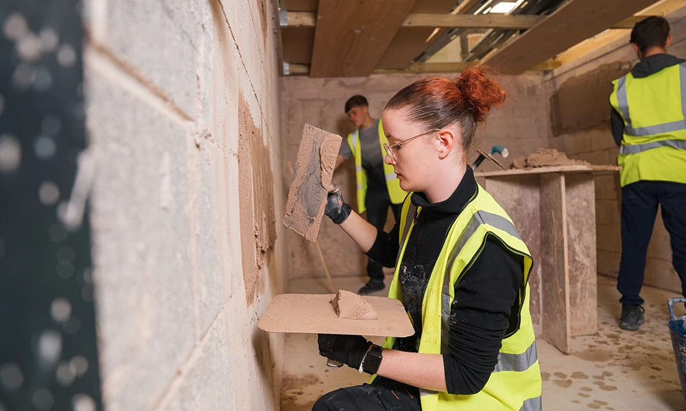 Woman Plastering a wall in HI Vis