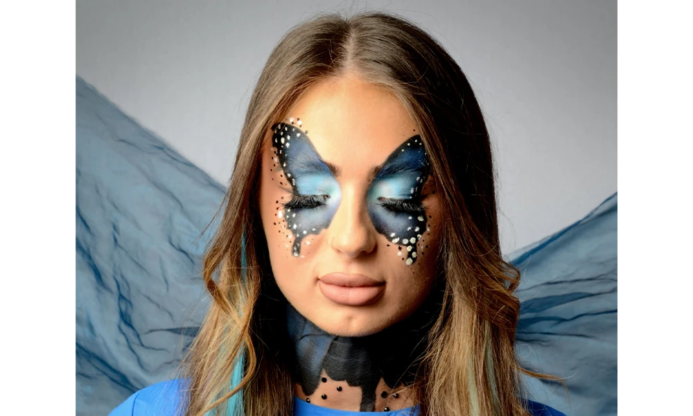 A woman with blue butterfly makeup on.