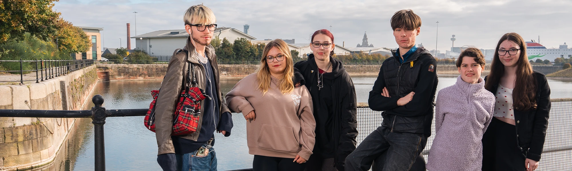 Six students stood infront of railings and a river