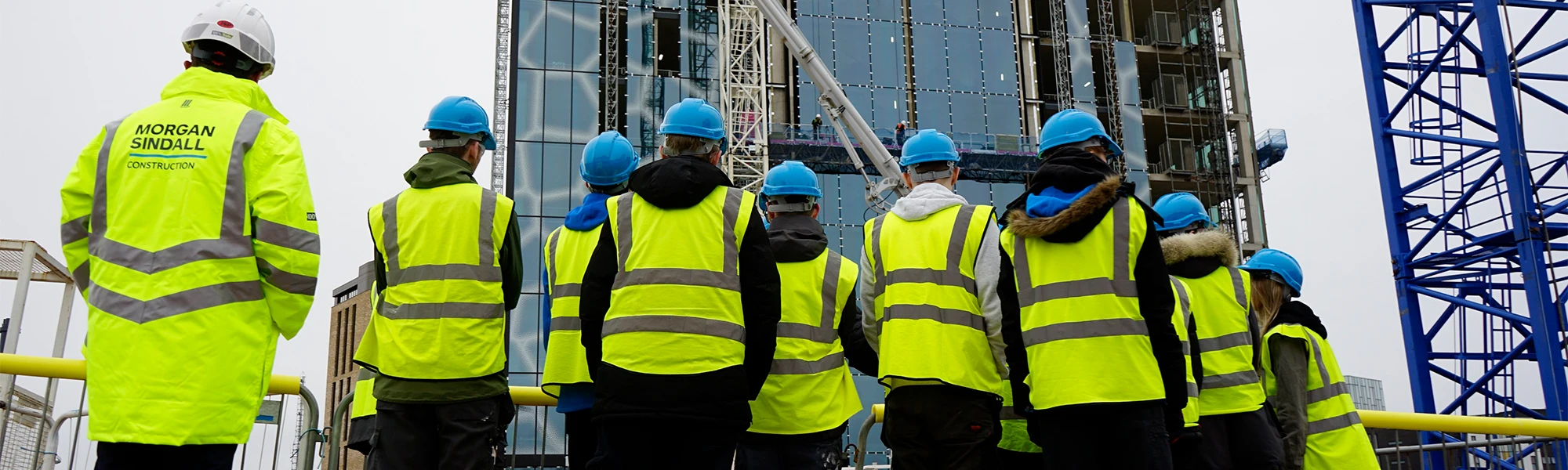 People in Hi Vis looking at high rise building