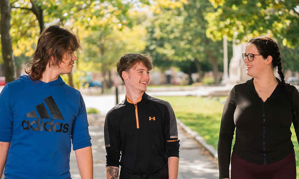 Three students walking towards the camera