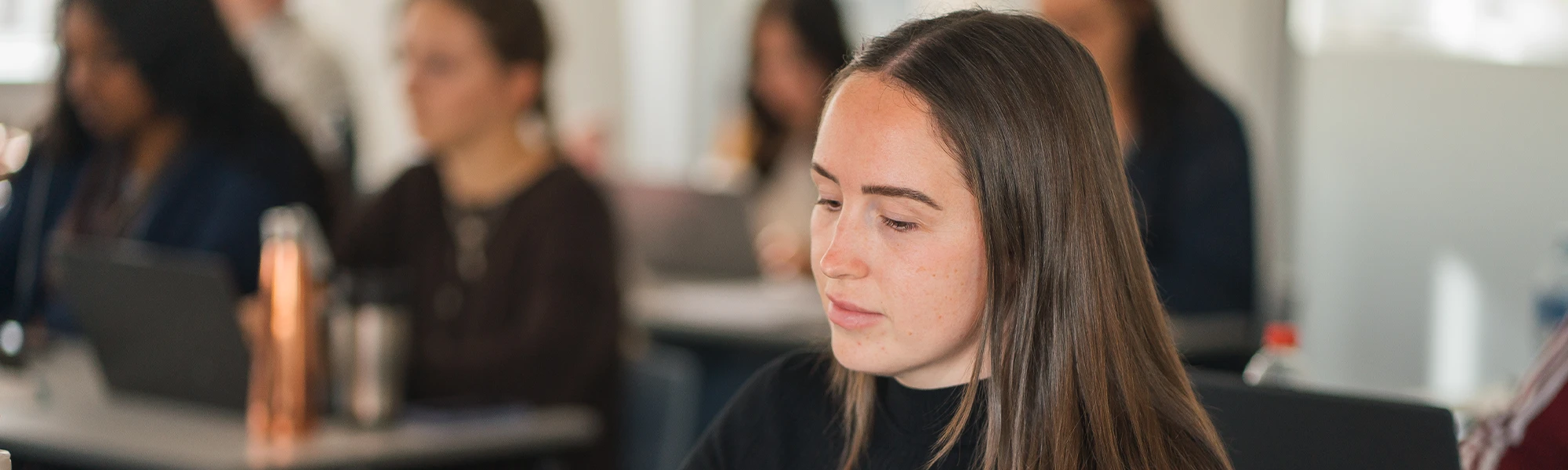 Female student sat inside classroom at Hamilton campus