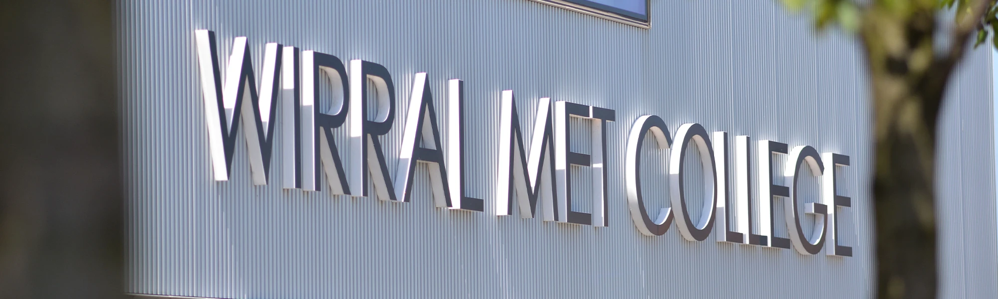 Wirral Met College written on a sign outside of Wirral Waters campus at daytime