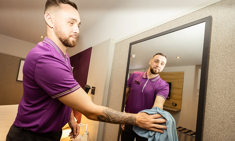 Premier Inn Supported internship student wiping mirror