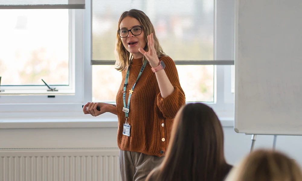 Teaching student standing at the front of class