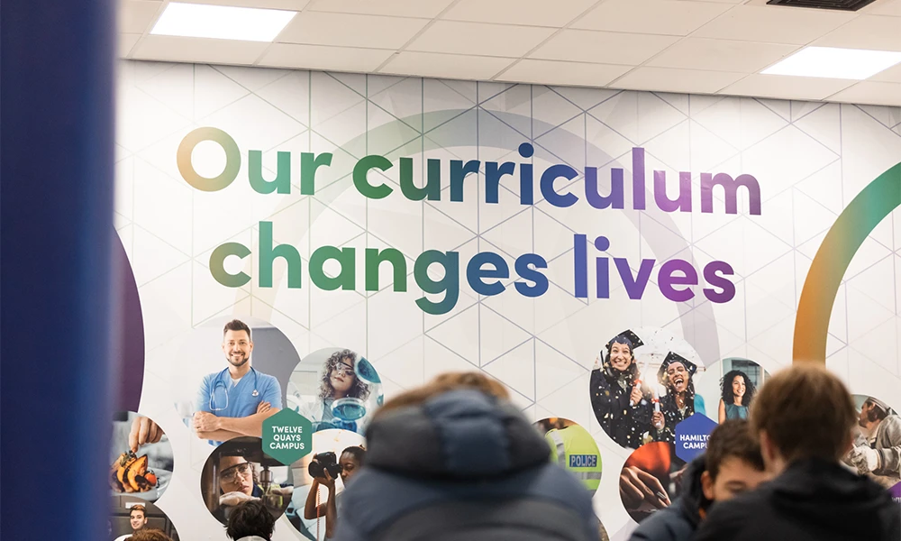Twelve Quays break out area with writing on wall saying 'our curriculum changes lives'