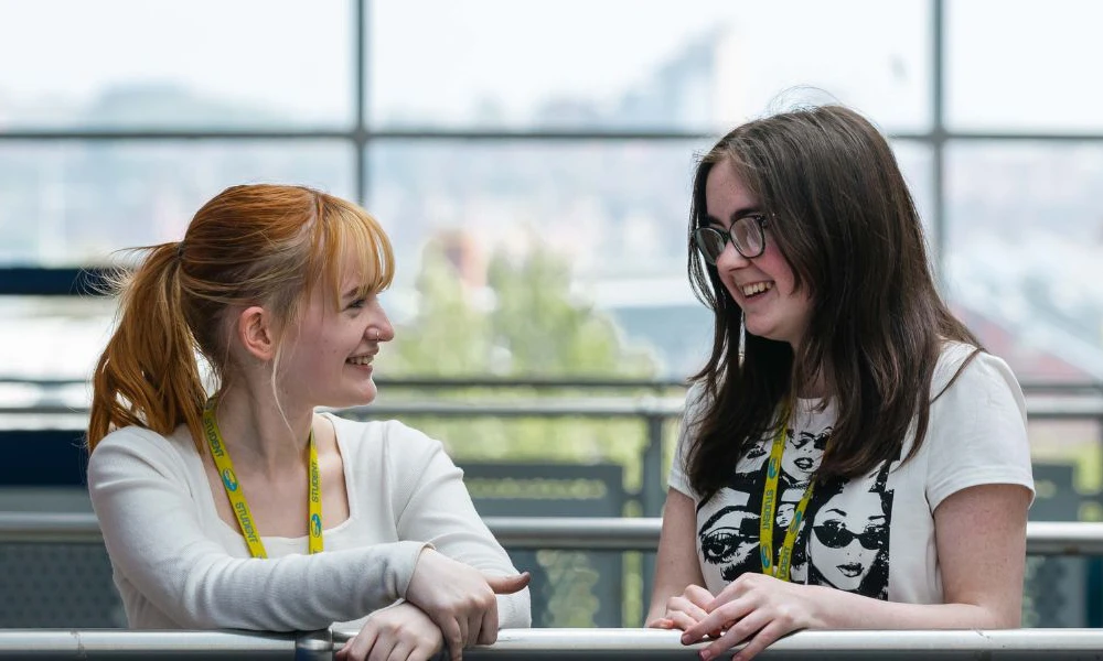 Two students standing on balcony at Twelve Quays campus