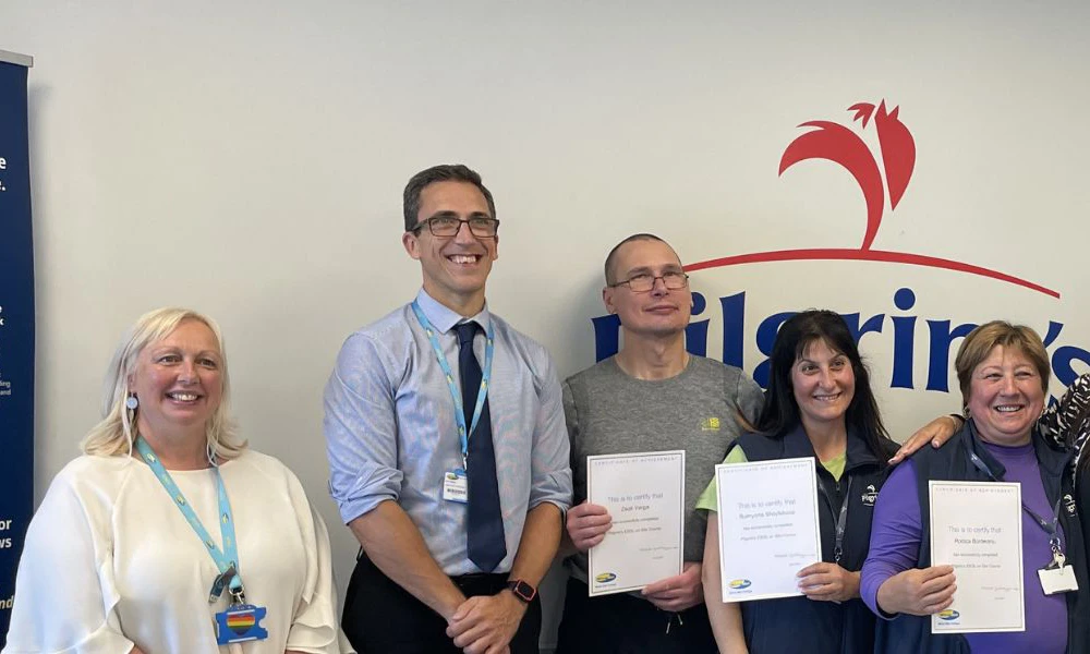 Wirral Met staff having picture taken next to students and Pilgrim's UK employees