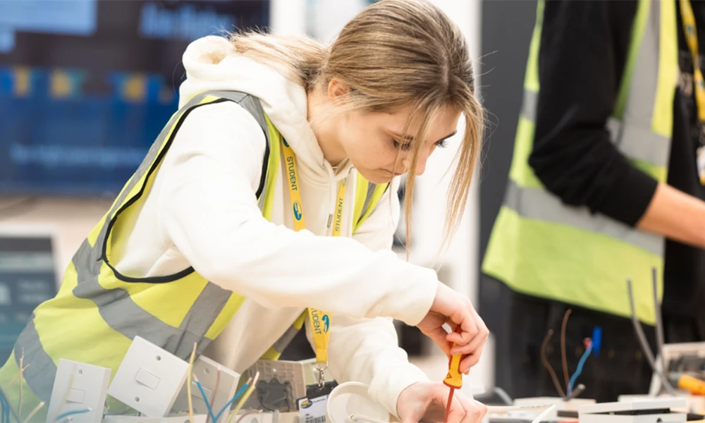 A woman with a screwdriver in hi vis