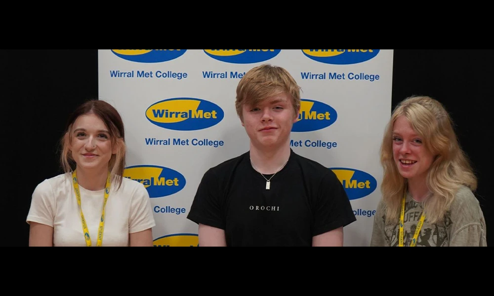 Three WorldSkills UK students posing in front of banner