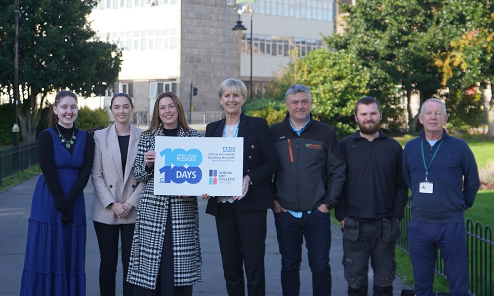 Wirral Met Principal Gill Banks standing with members of Wirral University Teaching Hospital at celebration event