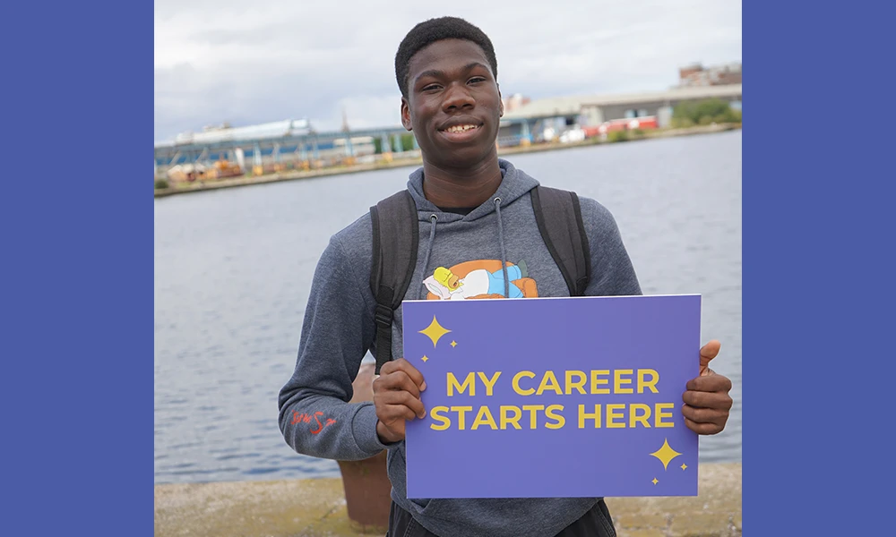 Man holding a sign that says My Career Starts Here whilst celebrating BTEC Results Day