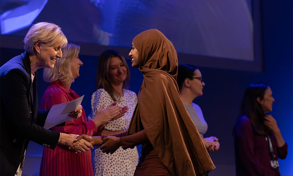 Female student receiving her awar from the Principal as she crosses the stage