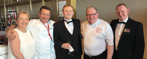 Principle Sue Higginson wearing white stadning next to Alumni Hospitality and Catering students Paul Askew and James Gibbs